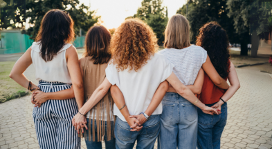 Eine Frauengruppe, hinter den Rücken gegenseitig die Hände haltend