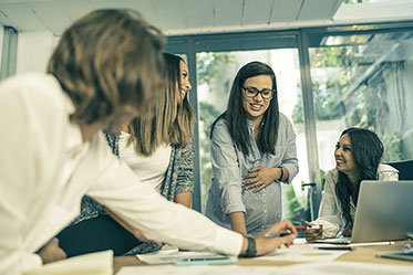 Vergrößerungsansichten für Bild: Am Arbeitsplatz: Gruppe von Frauen im Gespräch. Eine von ihnen ist schwanger.