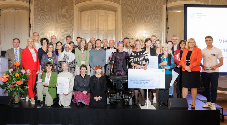 Foto: Bayerns Sozialministerin Ulrike Scharf (vorne links) verleiht gemeinsam mit der Ehrenamtsbeauftragten der Bayerischen Staatsregierung, Gabi Schmidt (vorne rechts), den Bayerischen Innovationspreis Ehrenamt im Schloss Nymphenburg. 